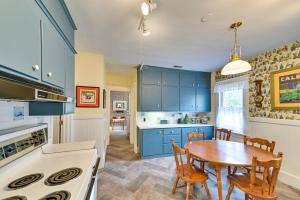 uma cozinha com armários azuis e uma mesa de madeira em Charming Pet-Friendly Vacation Rental with Backyard! 