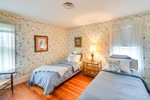 2 camas en una habitación con papel pintado floral en Charming Pet-Friendly Vacation Rental with Backyard!, 