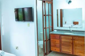 a bathroom with a sink and a mirror at Res Village do Bosque 03 in Porto Seguro
