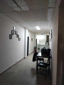 a hallway with a table and chairs in a room at La Gran Mansión en el corazón de Pereira in Pereira