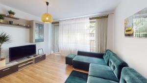 a living room with a green couch and a television at Kotlarska 7 TectumApartments in Wrocław