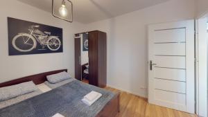 a bedroom with a bed and a picture of a bike on the wall at Kotlarska 7 TectumApartments in Wrocław