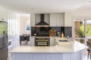 een keuken met witte kasten en een fornuis met oven bij Cullengetty Estate in Berry