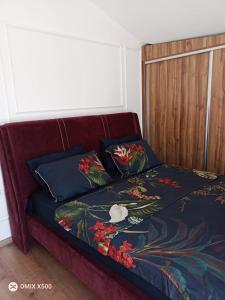 a red couch with two pillows on a bed at Dublex house - near the Airport and sea and in the city in Dalaman
