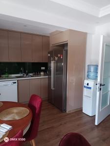 a kitchen with a stainless steel refrigerator and a table at Dublex house - near the Airport and sea and in the city in Dalaman