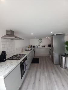 a kitchen with white counters and a stove top oven at NO 27 Apartment in Llandudno