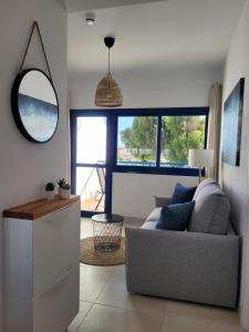 ein Wohnzimmer mit einer Couch und einem Spiegel in der Unterkunft Casa Nalu - Costa Calma Sun & Pool in Costa Calma