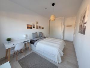 ein weißes Schlafzimmer mit einem Bett und einem Schreibtisch in der Unterkunft Casa Nalu - Costa Calma Sun & Pool in Costa Calma + 20 Fotos