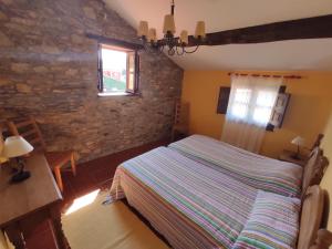 a bedroom with a bed and a stone wall at La casina del pozo en Cudillero, As. VV-360-AS in Cudillero +17 photos