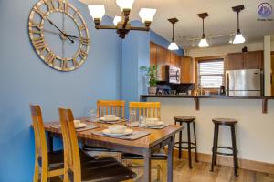 uma sala de jantar e cozinha com um grande relógio na parede em Fire Mountain Two Bedroom Condo em Canmore