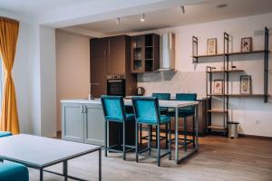 a kitchen with blue chairs and a table in a room at Darki Comfort Apartments - Stylish Apartments with Free Parking in Tranquil Area in Ohrid