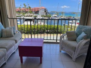 a living room with a balcony with a view of a harbor at Sapphire Dream in St Thomas