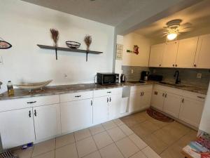 a kitchen with white cabinets and a microwave at Sapphire Dream in St Thomas