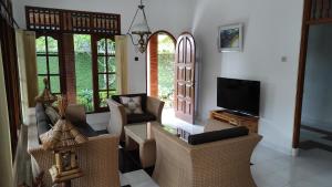 sala de estar con sillas y TV de pantalla plana en Keyani Bungalows Lovina en Lovina