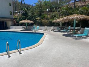 a swimming pool with chairs and tables and umbrellas at Sapphire Dream in Nazareth