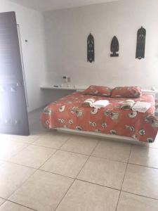 1 dormitorio con 1 cama con edredón rojo en Private beach house beside the sea., en Chicxulub
