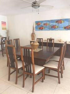 comedor con mesa de madera y sillas en Private beach house beside the sea., en Chicxulub