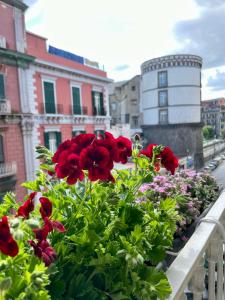 um ramo de flores vermelhas numa varanda em Napoli Comfort Home em Nápoles