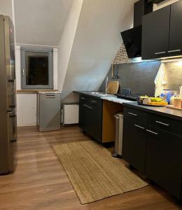 a kitchen with black cabinets and a counter top at Boho Apartment in der Stadtmitte in Lahr