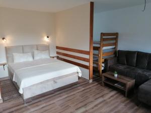 um quarto com uma cama e um sofá em Seosko domaćinstvo Kastratović em Berane