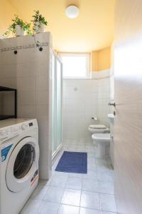 a bathroom with a washing machine and a toilet at LOFT TIRANO 3min walk to BerninaExpress in Tirano