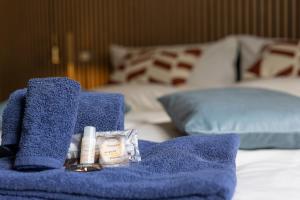 a blue towel and cosmetics sitting on a bed at LOFT TIRANO 3 minuti dal Bernina Express in Tirano