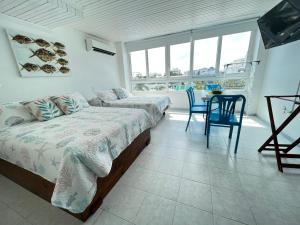 1 dormitorio con 2 camas, mesa y sillas en Apartamentos Bahia Fragata, en San Andrés