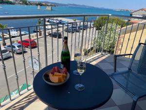a bottle of wine and a bowl of fruit on a table on a balcony at Old Town Heritage by Mrav in Sukošan