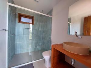 a bathroom with a shower and a sink and a toilet at Casa Prosperidade in Alto Paraíso de Goiás