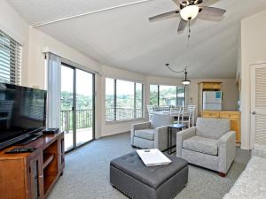 a living room with a flat screen tv and chairs at Lakefront Bungalow With Pool & Hot Tub #10 in Lakeway