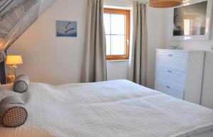 a bedroom with a white bed and a window at Ort Lemkenhafen Ostseeperle in Fehmarn
