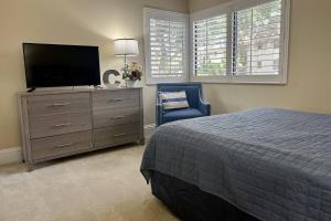 a bedroom with a bed and a dresser with a television at Newly Listed! 20 Percent Off! Golf and Tennis Community Retreat in Wesley Chapel