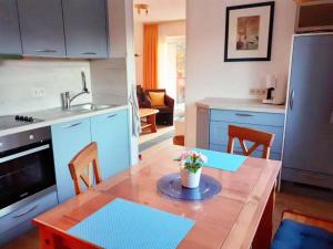a kitchen with a table and a kitchen with blue cabinets at Ort Lemkenhafen Stüven 20 in Fehmarn
