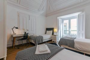 a white bedroom with a desk and a bed and a desk at Bairro Alto Palace Special for Groups in Lisbon