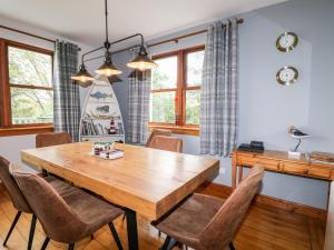 a dining room with a wooden table and chairs at Clearwater House in Lochailort