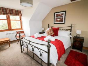a bedroom with a large bed with red pillows at Clearwater House in Lochailort