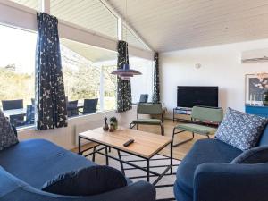 ein Wohnzimmer mit 2 blauen Sofas und einem TV in der Unterkunft Holiday home Skals VI in Skals