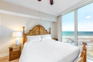 ein Schlafzimmer mit einem Bett und einem großen Fenster in der Unterkunft Portofino Island Resort & Spa 1-902 in Pensacola Beach