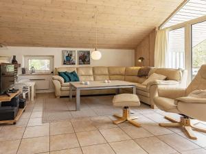 uma sala de estar com um sofá e uma mesa em Three-Bedroom Holiday home in Blåvand 16 em Ho