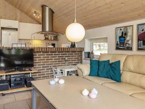 uma sala de estar com um sofá e uma mesa em Three-Bedroom Holiday home in Blåvand 16 em Ho