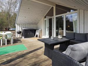 un patio con sofá, mesa y sillas en Three-Bedroom Holiday home in Blåvand 16, en Ho