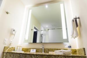 La salle de bains est pourvue d'un lavabo et d'un grand miroir. dans l'établissement Courtyard by Marriott San Luis Potosi, à San Luis Potosí