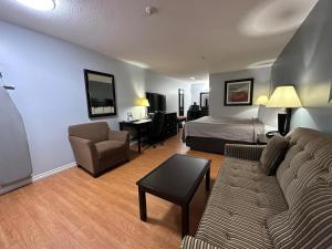 a living room with a bed and a couch and a bed and a room with at Kenora Motel in Windsor
