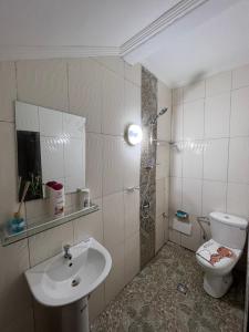 a bathroom with a toilet and a sink at RÉSIDENCE MEUBLÉE 1ERE CLASSE DOUALA pk 15 in Douala