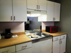 una cocina con armarios blancos y fregadero en Executive Inn, en Mena
