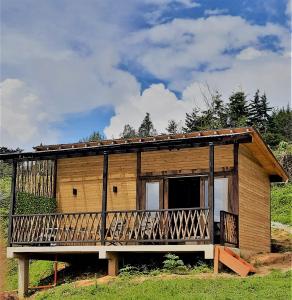 ein kleines Holzhaus mit einer großen Terrasse in der Unterkunft Carriquí Glamping in Gómez Plata
