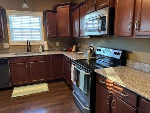 a kitchen with wooden cabinets and a stove top oven at Five Stars Luxury Home in Clarksville