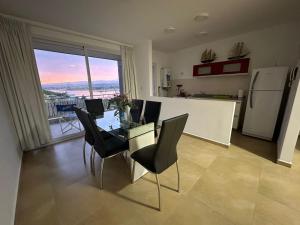 cocina con mesa y sillas y vistas en Departamento Fragata en Villa Ciudad de América