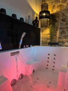een badkamer met een bad gevuld met rood water bij La Planque - Chambres avec Jacuzzi in Fleury-en-Bière
