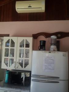a kitchen with a microwave and a refrigerator at Conforto e comodidade em Santa Maria in Santa Maria